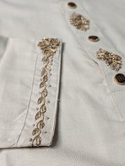 Close-up of gold-tone stonework on the sleeve cuff and button placket